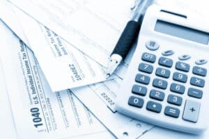 calculo de numeros para declaracao de imposto de renda com caneta e calculadora